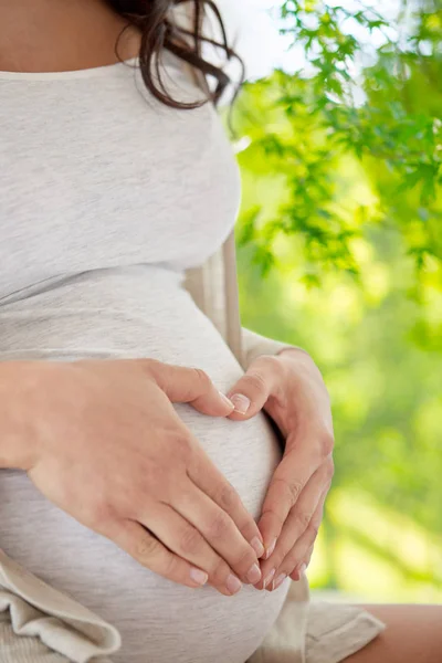 Close up of pregnant woman making heart gesture — Stock Photo, Image