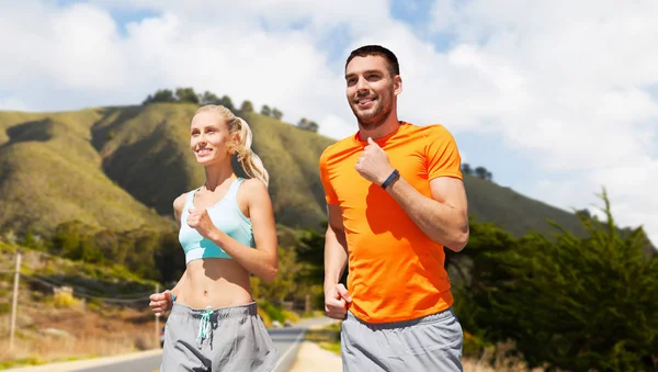 Sorridente coppia che corre su grandi colline sur — Foto Stock