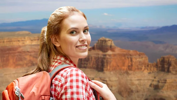 Mujer sonriente con mochila sobre gran cañón — Foto de Stock