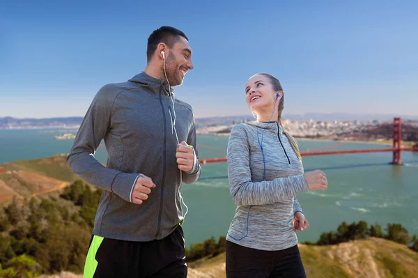 Coppia con auricolari sopra san francisco — Foto Stock