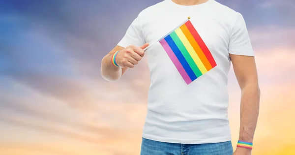 Mężczyzna z tęczową flagą i gej duma bransoletki — Zdjęcie stockowe