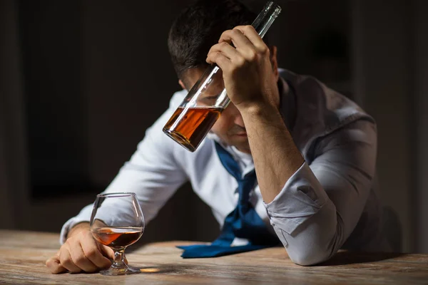 Bêbado homem beber álcool à mesa à noite — Fotografia de Stock