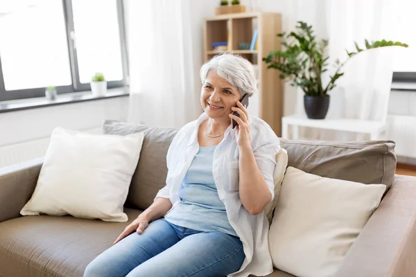 Senior woman calling on smartphone at home — Stock Photo, Image