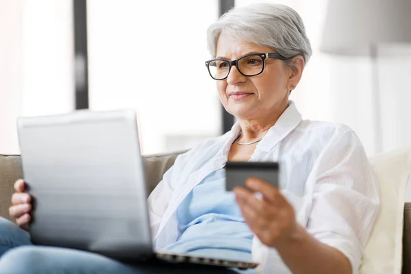 Idősebb nő laptoppal és hitelkártyával otthon — Stock Fotó