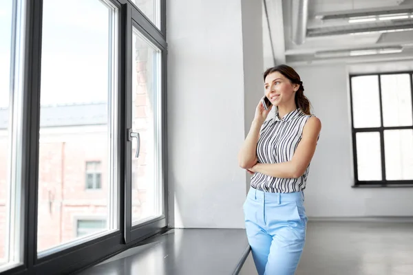 Empresária chamando no smartphone no escritório — Fotografia de Stock