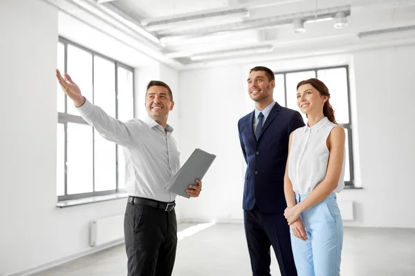 Corretor de imóveis mostrando nova sala de escritório para os clientes — Fotografia de Stock