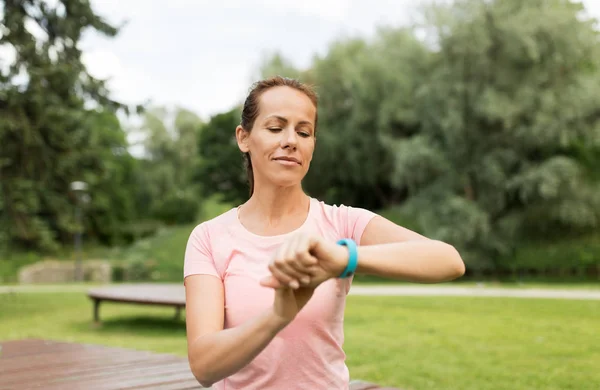 Žena s fitness tracker v parku — Stock fotografie