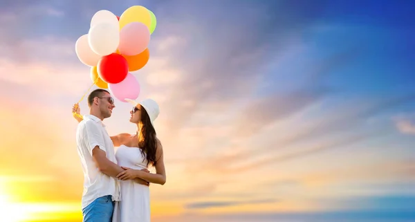 Casal feliz com balões sobre o céu por do sol Imagens De Bancos De Imagens