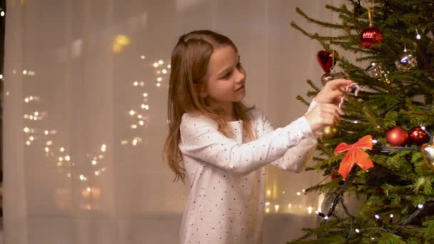 Chica feliz decorando el árbol de Navidad en casa — Vídeos de Stock