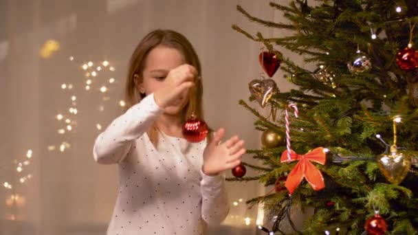 Chica feliz decorando el árbol de Navidad en casa — Vídeos de Stock