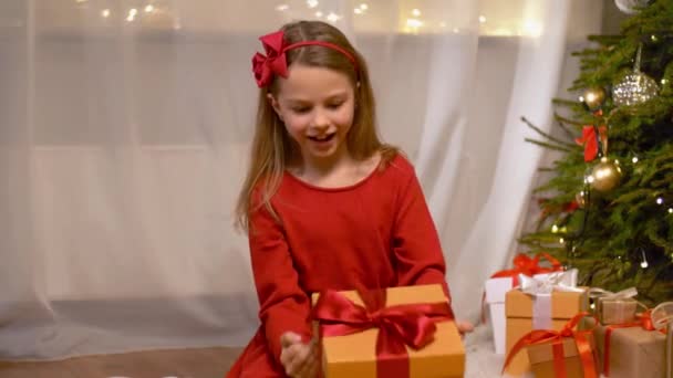 Gelukkig meisje openen de gift van Kerstmis thuis — Stockvideo