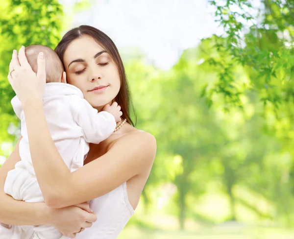 Mère avec bébé sur fond naturel vert — Photo