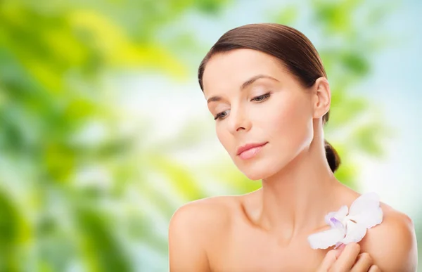 Mujer con flor de orquídea sobre fondo verde —  Fotos de Stock