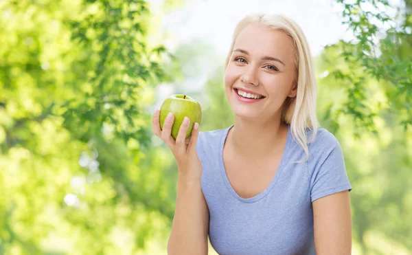 Glada leende kvinna med grönt äpple — Stockfoto