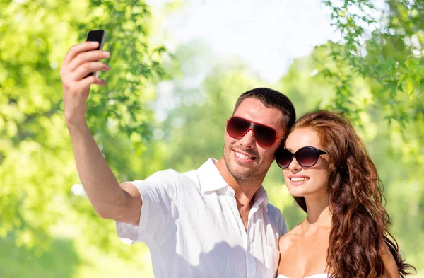 Sonriente pareja haciendo selfie por teléfono inteligente — Foto de Stock