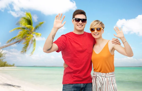 Pareja en gafas de sol abrazando y saludando las manos — Foto de Stock