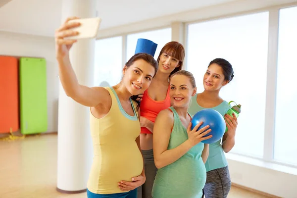 Hamile kadın yanında smartphone içinde jimnastik salonu selfie alarak — Stok fotoğraf