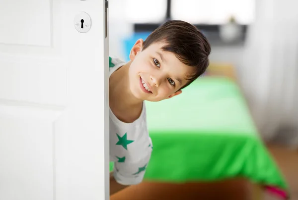 Glücklicher kleiner Junge hinter Tür zu Hause — Stockfoto