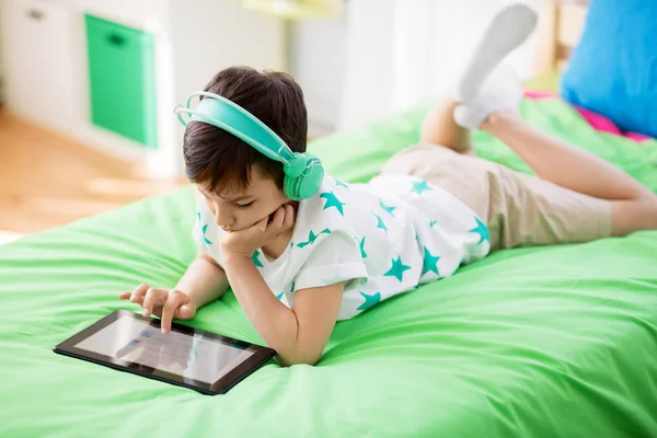 Boy with tablet pc and headphones at home — Stock Photo, Image