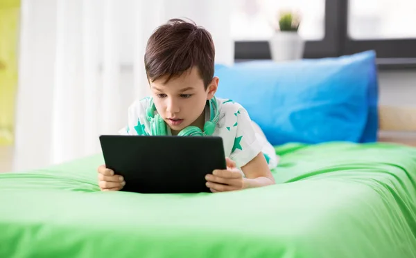 Menino com tablet pc jogo de computador em casa — Fotografia de Stock