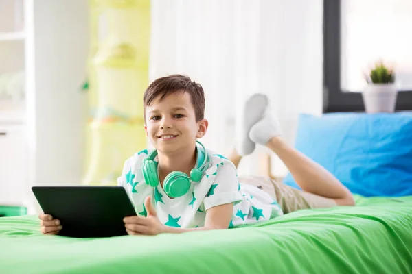 Lachende jongen met tablet pc thuis pc — Stockfoto