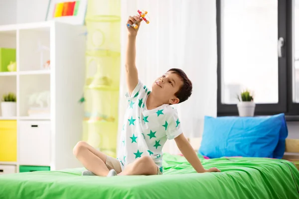 Glücklicher kleiner Junge spielt zu Hause mit Flugzeugspielzeug — Stockfoto