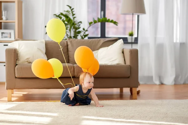 Encantadora pelirroja bebé chica con globos en casa —  Fotos de Stock
