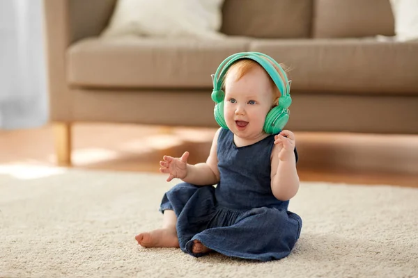 Ruiva bebê menina em fones de ouvido ouvir música — Fotografia de Stock