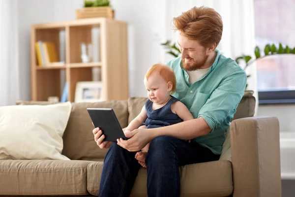 父亲和婴孩女儿用平板电脑在家 — 图库照片