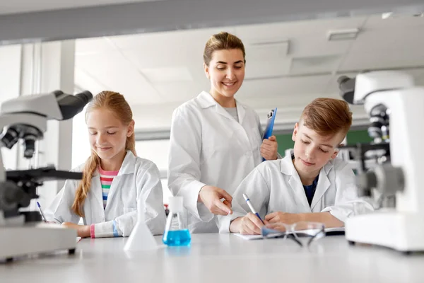 teacher and students studying chemistry at school