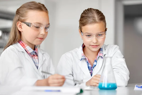 Filles avec tube à essai étudiant la chimie à l'école — Photo