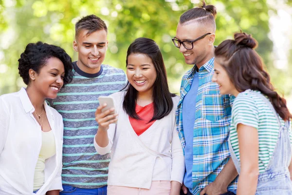 Grupp av glada vänner med smartphone utomhus — Stockfoto