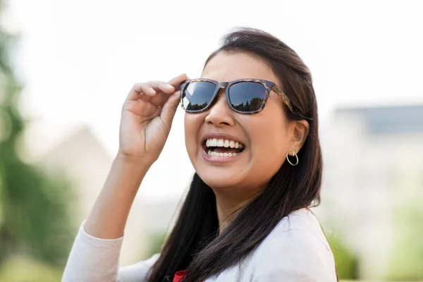 Portret van een jonge vrouw in zonnebril buitenshuis — Stockfoto