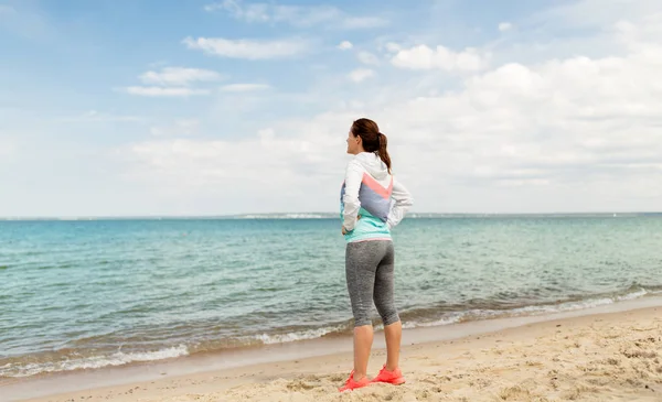 Vrouw in de sport kleding op strand — Stockfoto