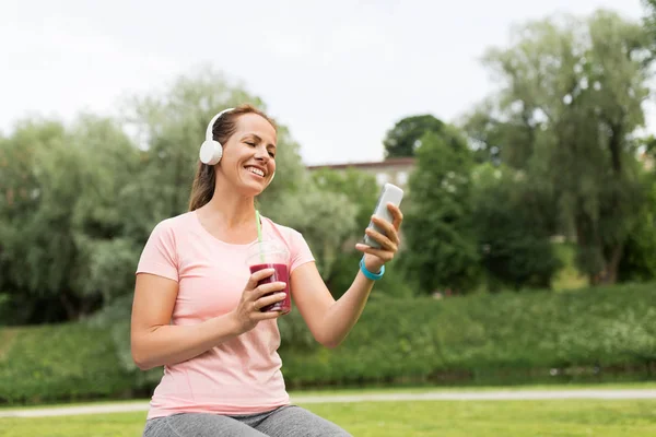 Vrouw met smartphone en schud luisteren naar muziek — Stockfoto