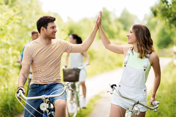 Pareja con bicicletas haciendo high five en verano —  Fotos de Stock