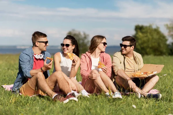 Amici che mangiano pizza al picnic nel parco estivo — Foto Stock
