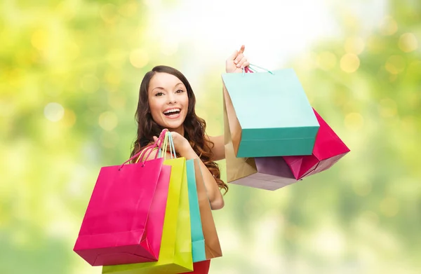 Junge lächelnde Frau mit Einkaufstüten über Lichtern — Stockfoto