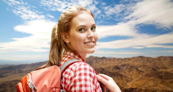 Mulher sorridente com mochila sobre montanhas — Fotografia de Stock