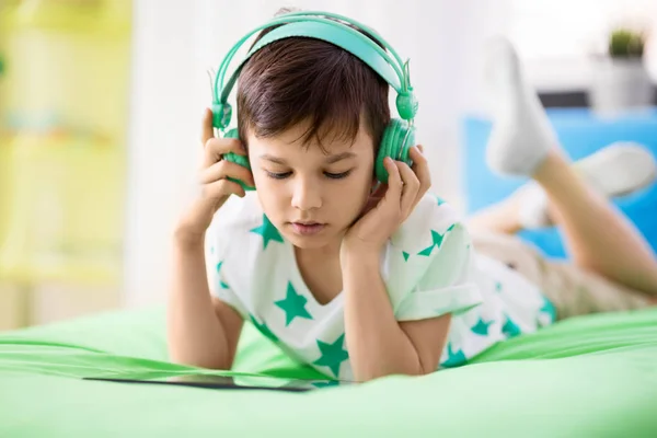 Jongen met tablet pc en hoofdtelefoon thuis — Stockfoto