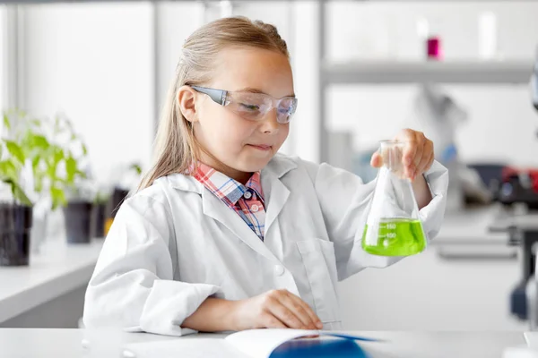 Девушка с пробиркой изучает химию в школе — стоковое фото