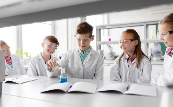 Niños con probeta que estudian química en la escuela — Foto de Stock