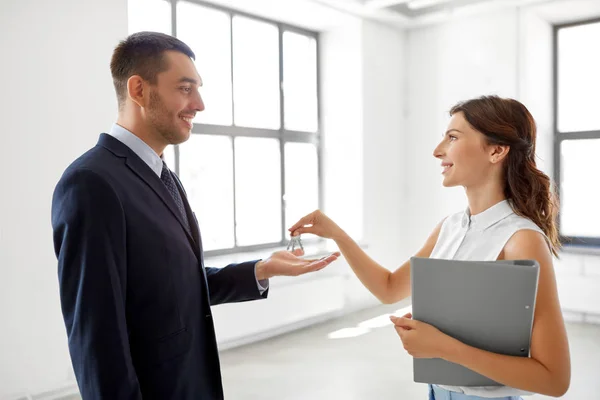 Makler übergibt Schlüssel an Kunden in neuem Büro — Stockfoto