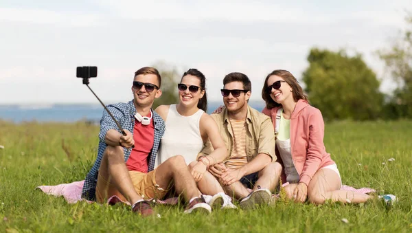 Amigos tomando foto por selfie palo en verano —  Fotos de Stock