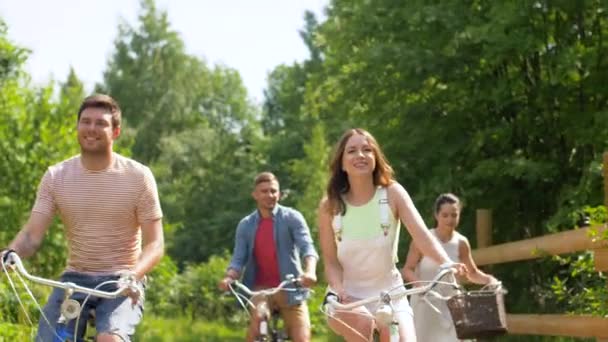 Amigos felices montando bicicletas de engranaje fijo en verano — Vídeos de Stock