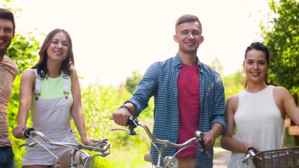 Счастливые друзья с велосипедами с фиксированной коробкой передач летом — стоковое видео