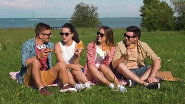 Vrienden eten pizza op picnic in tallinn park — Stockvideo