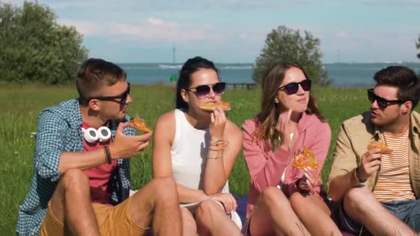 Freunde essen Pizza bei Picknick im Park von Tallinn — Stockvideo