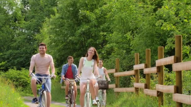 Amigos felices montando bicicletas de engranaje fijo en verano — Vídeo de stock