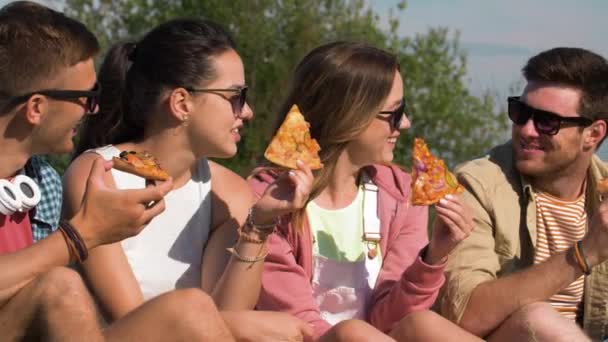 Amigos comiendo pizza en el picnic en el parque de verano — Vídeo de stock